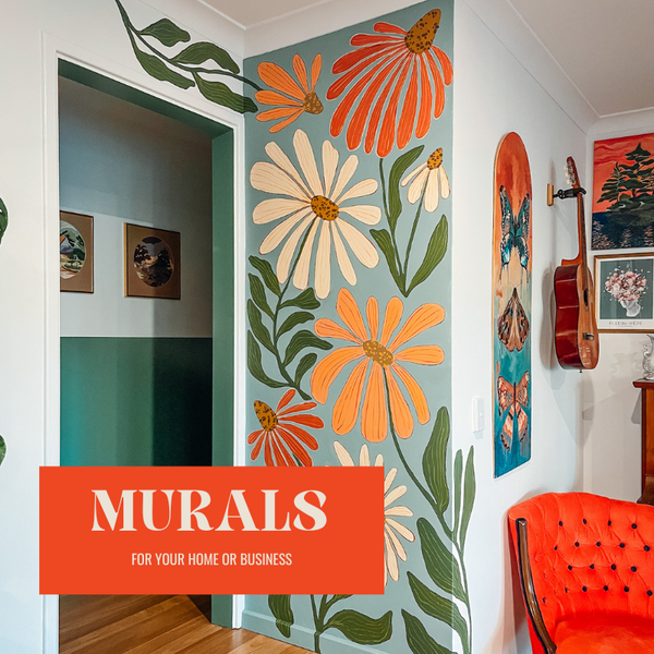 Vibrant floral mural featuring large orange and yellow daisies, painted on a wall in a modern home with a green and white color scheme.